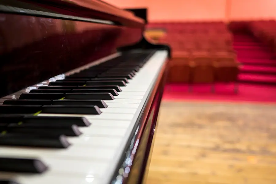 Teclado de um piano de cauda numa sala de concertos